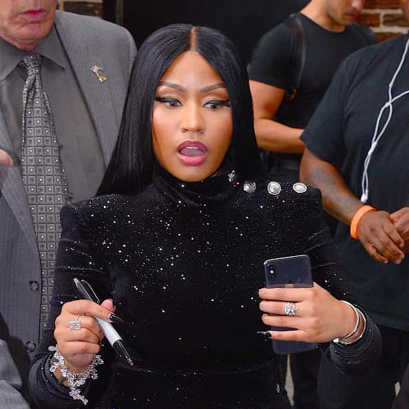 Nicki mInaj with phone in one hand and sharpie in the other
