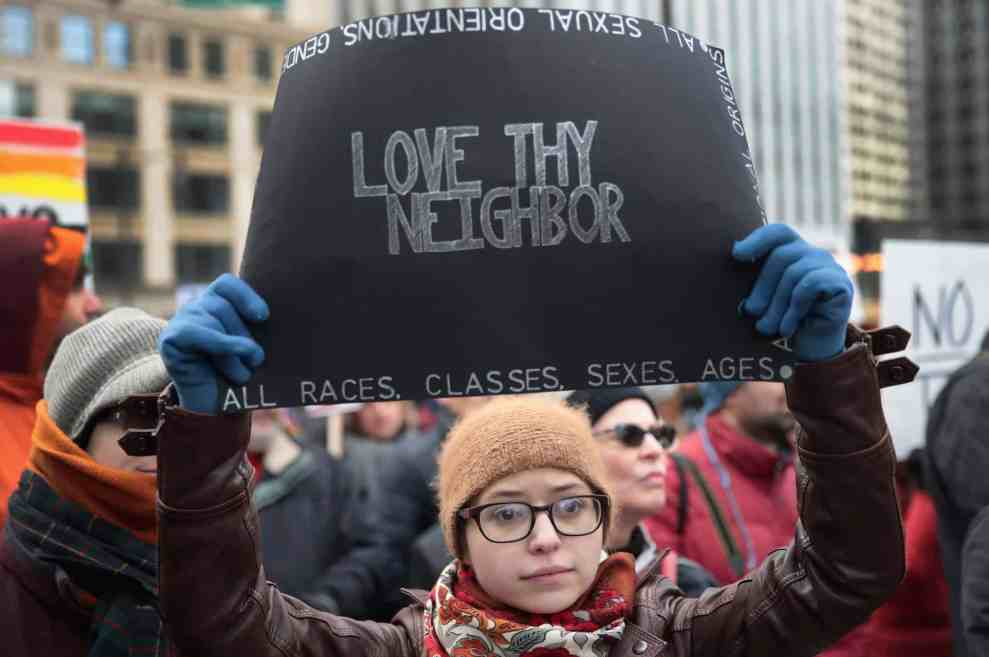 Woman holding up sign "Love Thy Neighbor"