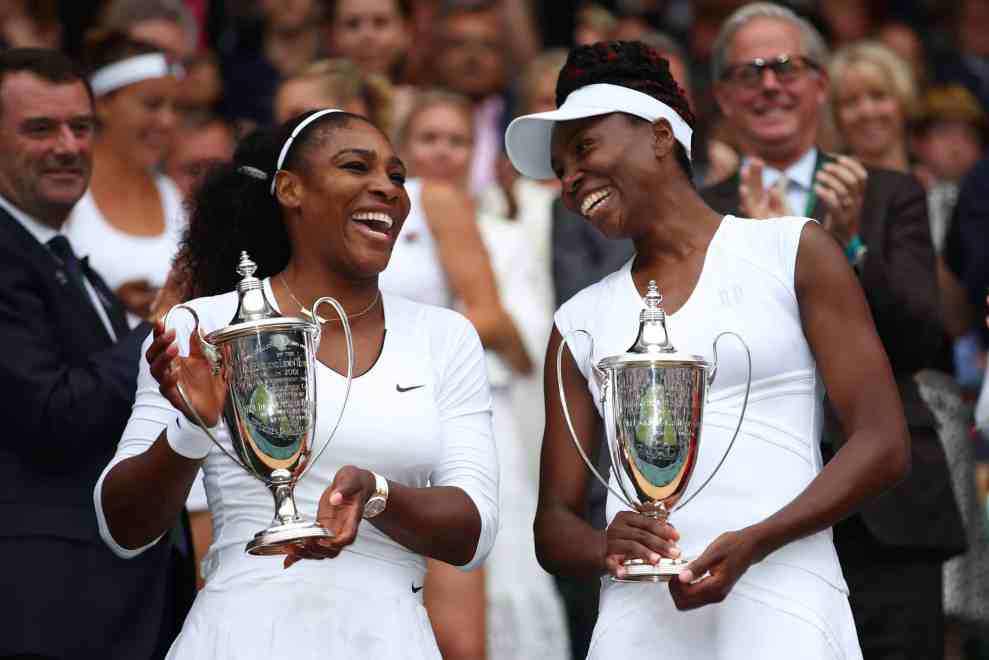 Serena and Venus Williams holding trophies