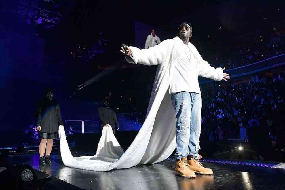 Diddy performing in long white coat at arena