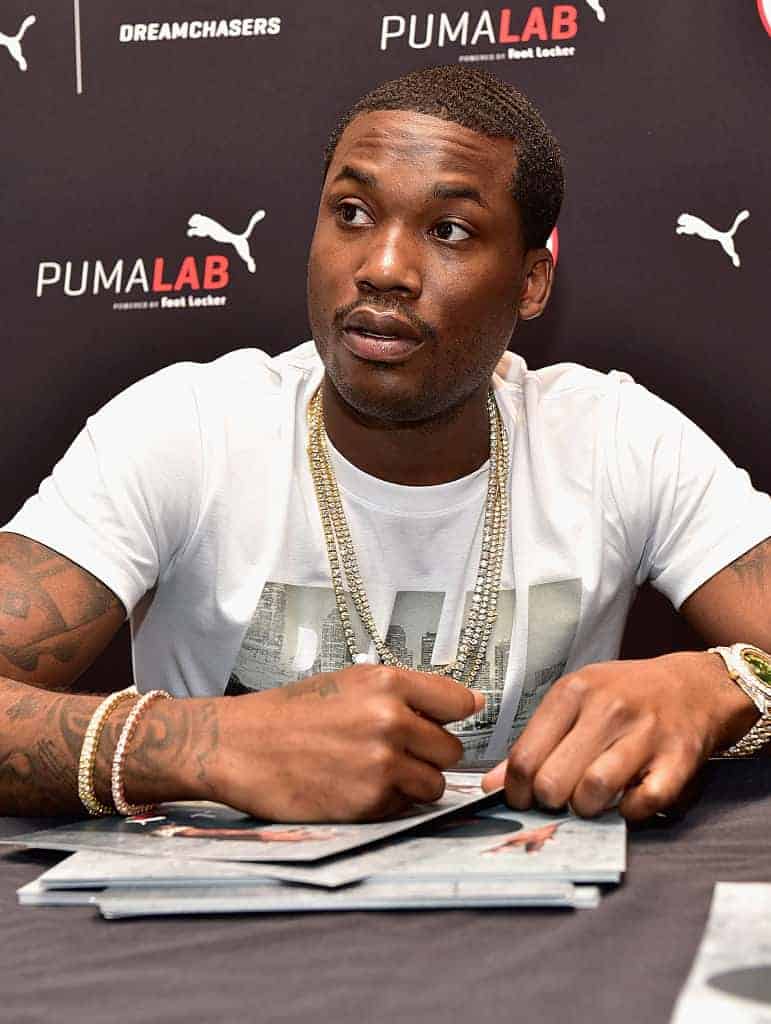 Meek Mill signing autographs in front of PumaLab Dreamchasers background