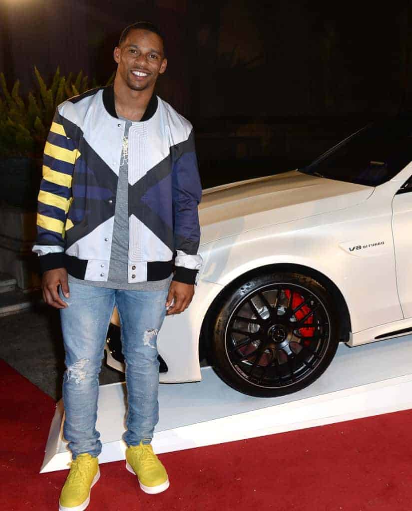 Victor Cruz in front of white car