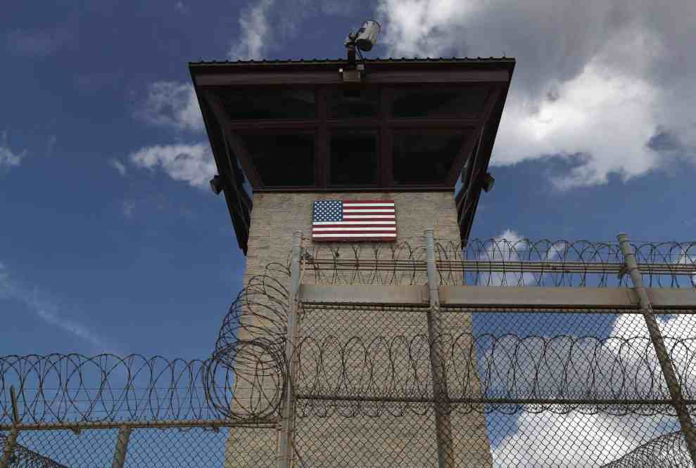 Prison with American Flag behind barbed wire fence