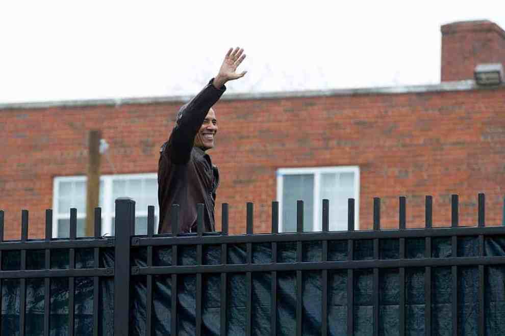 President Obama waving from behind a fence