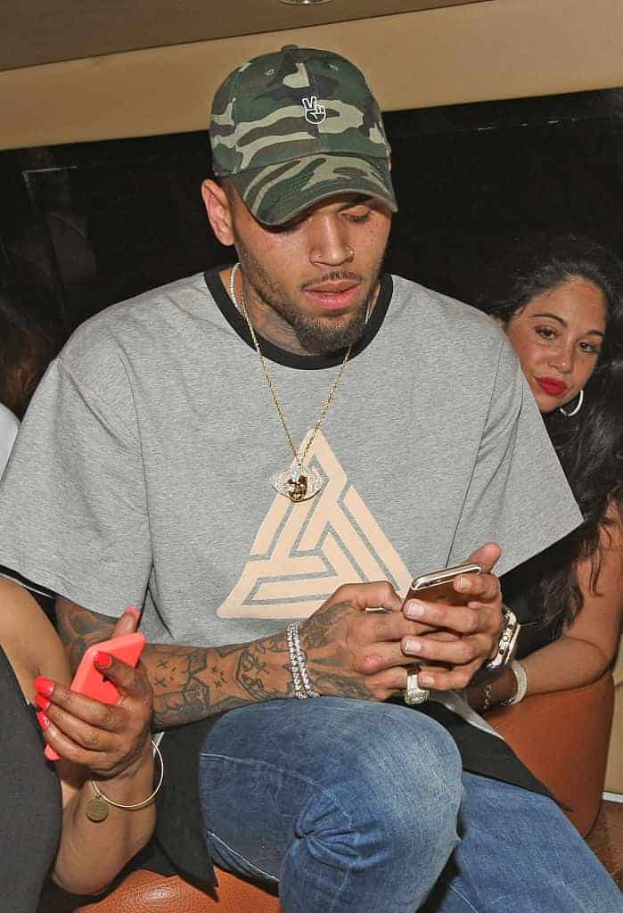 Chris Brown in Cammo hat on phone