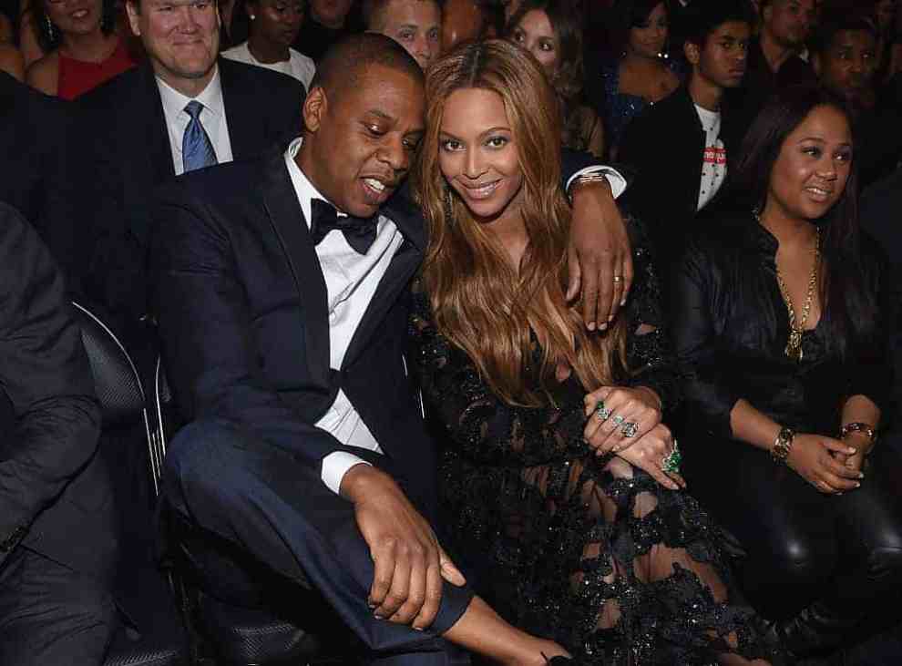 Jay Z with arm draped around  Beyoncé in formal wear at event