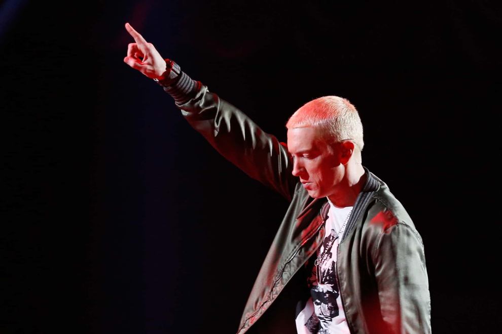 Eminem in all black with right hand pointing upwards