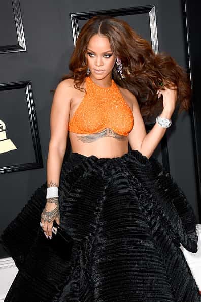 Rihanna at event in orange half shirt and black velvet skirt at the grammys
