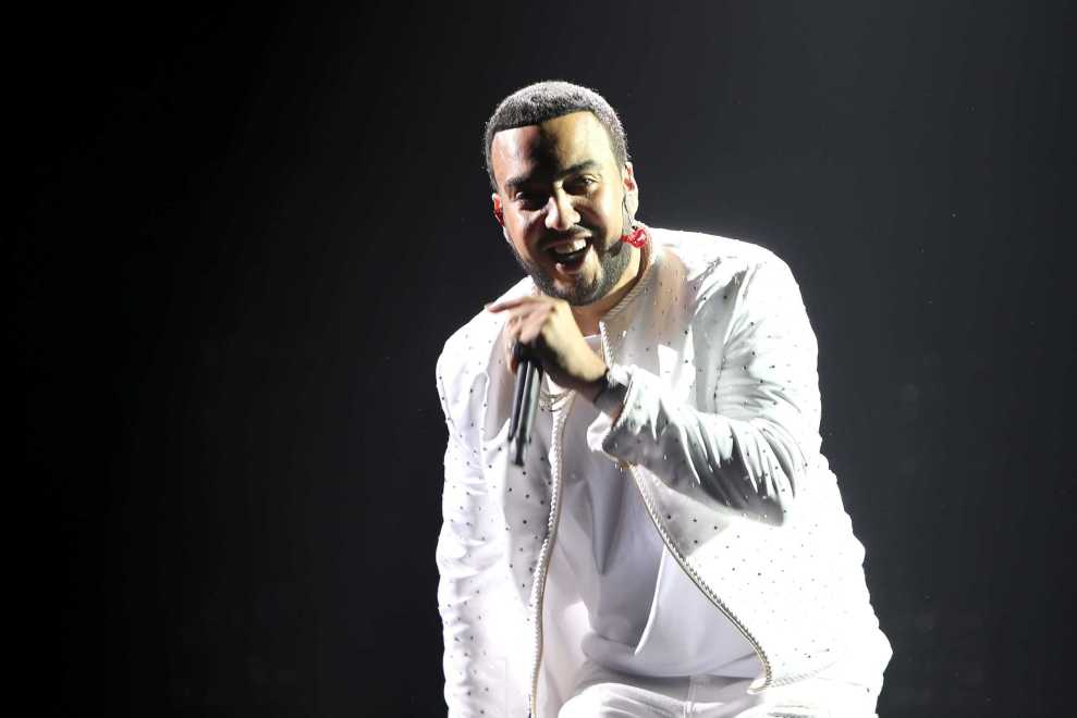 French Montana performing in all white against a black background