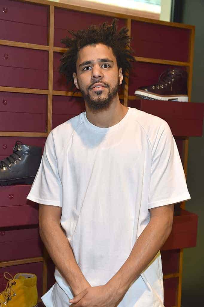 J. Cole in front of shoe display