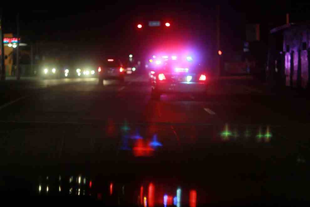 Police lights reflected on dark road