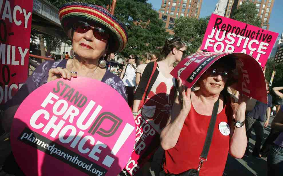 Pro Choice potest with women holding signs reading "Stand Up for Choice plannedparenthood.org and Reproductive Justice For All