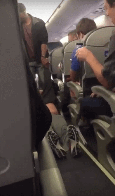 Screenshot of man being pulled off United Airline flight