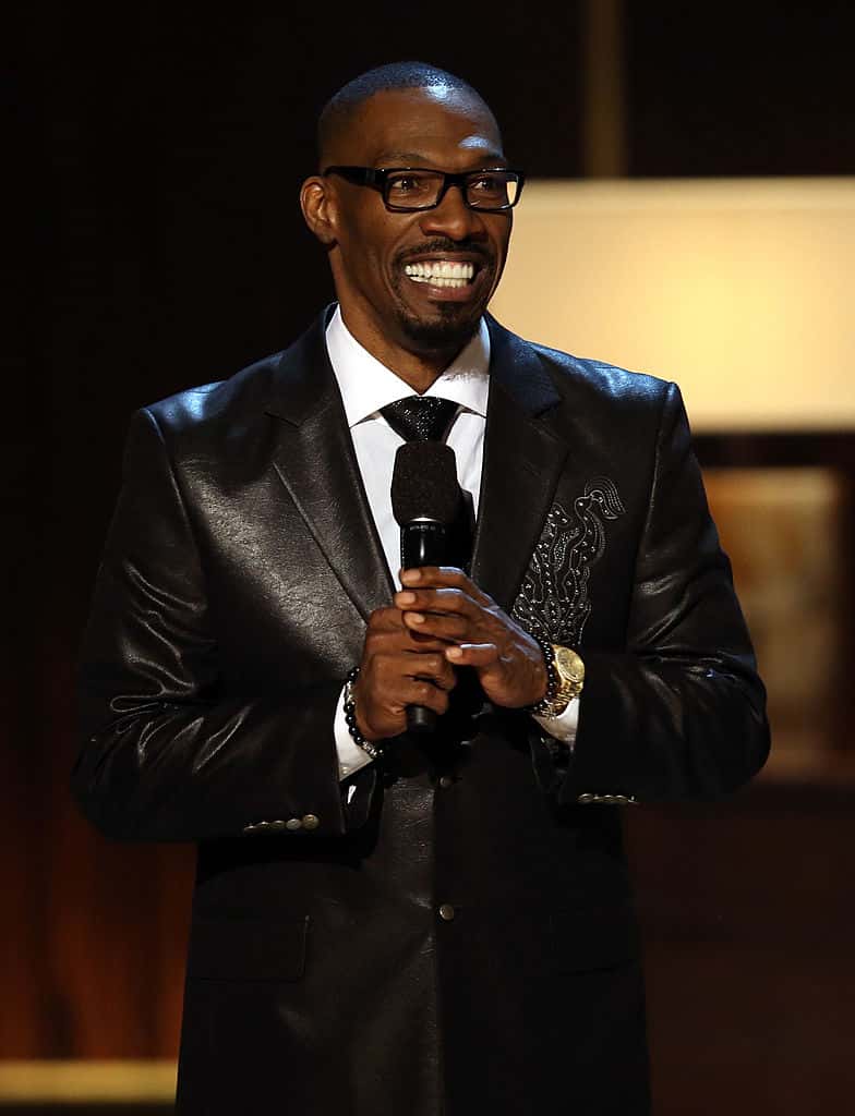 Charlie Murphy in black suit on stage with microphone