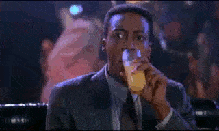 Gif of Arsenio Hall spitting out drink from Coming to America