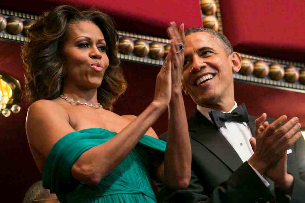 Michelle Obama giving standing ovation and Barack Obama standing next to her looking adoringly at her while also clapping