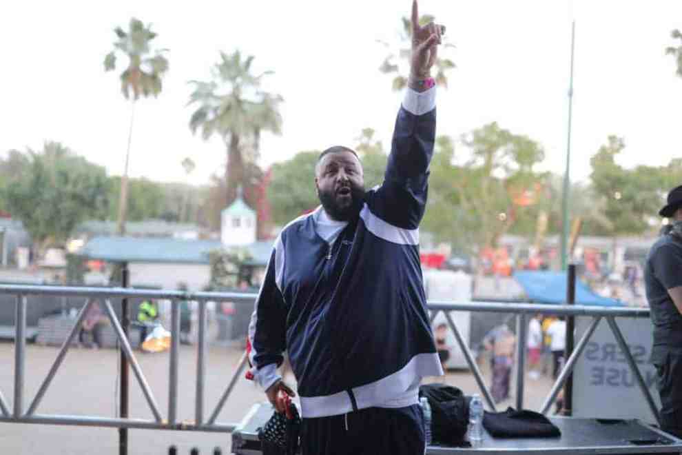 DJ Kahled giving peace sign in front of palm trees