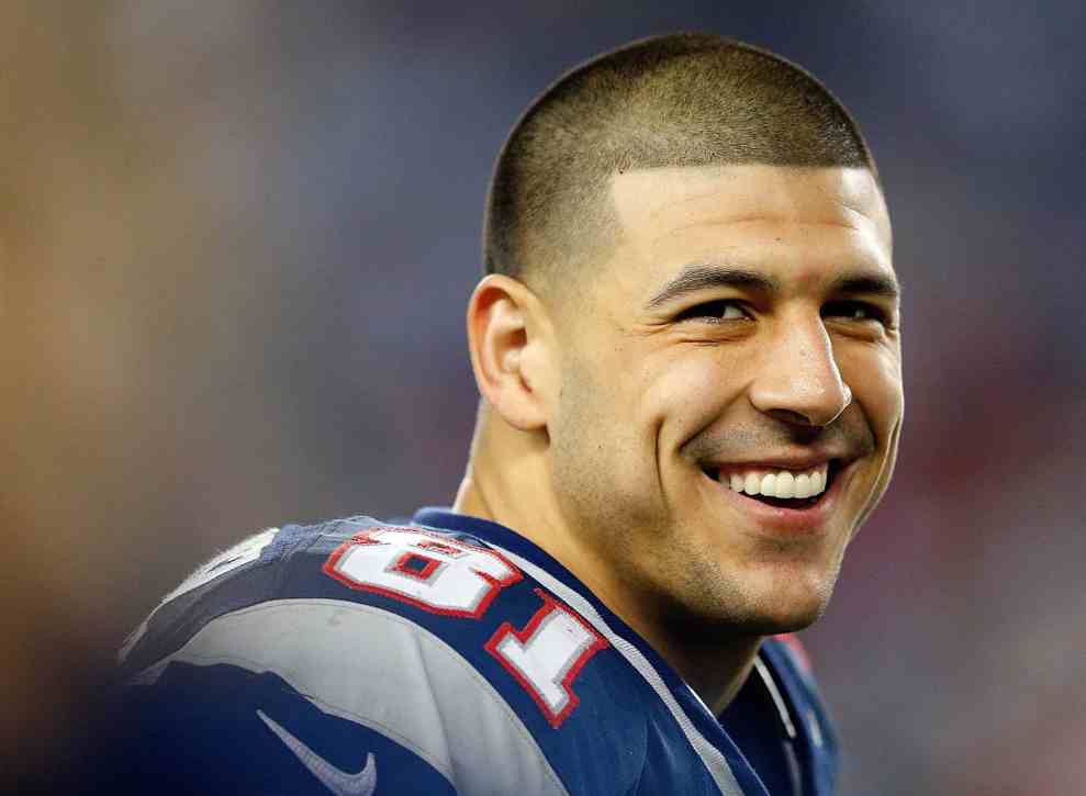 Aaron Hernandez smiling in #81 New England Patriots jersey on field