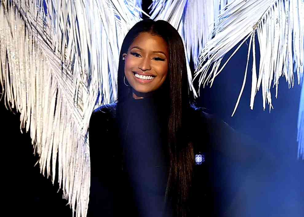 Nicki Minaj in front of blue background with white palms