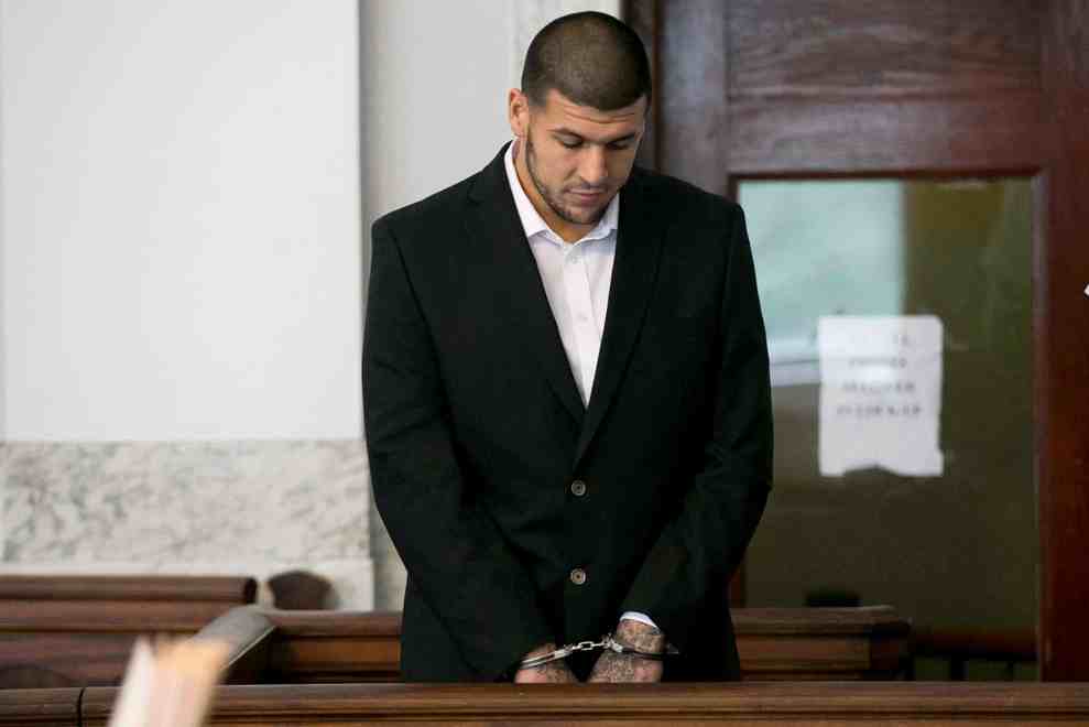 Aaron Hernandez in handcuffs standing in court