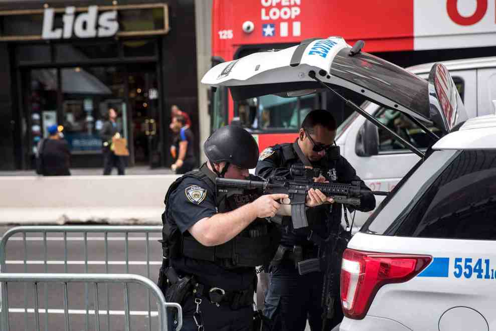 NYPD police officers with gun aimed at open trunk of car