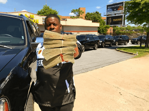 Blac Youngsta holding piles of cash from his Instagram account