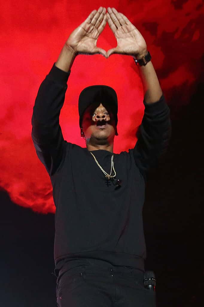 Jay Z throwing up the diamond hand gesture on stage