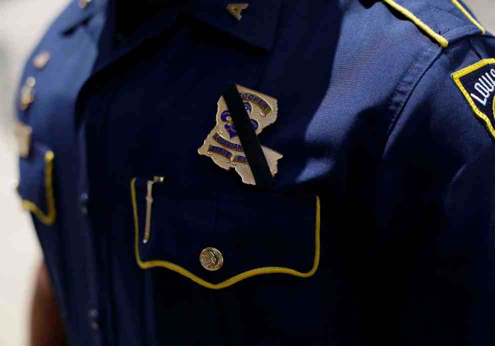 A black band is displayed around Louisiana State Police Officer Bryan Lee badge honoring officers Jackson