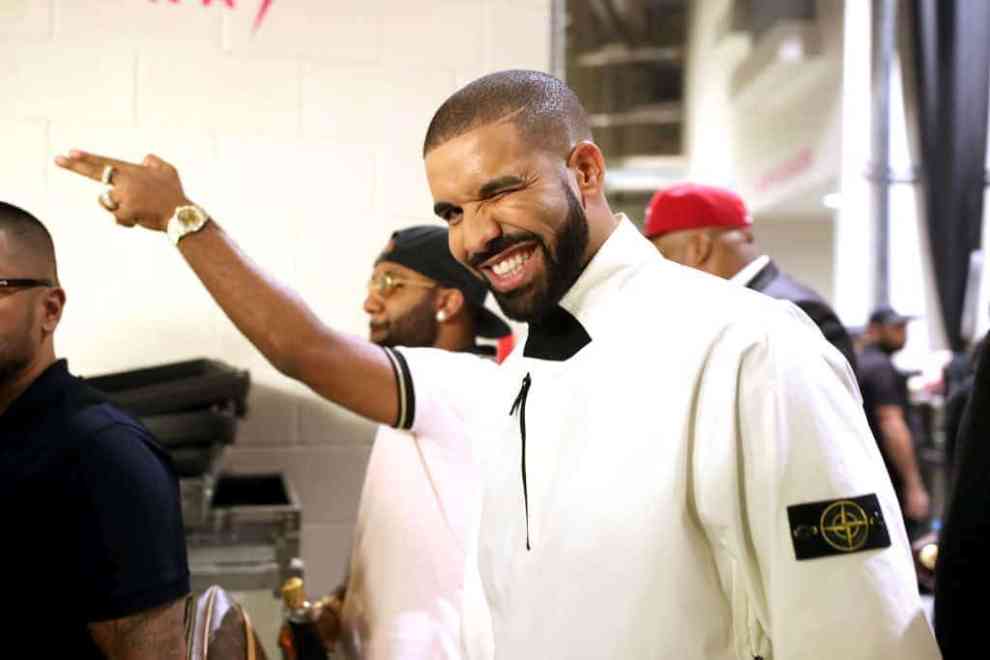 Drake smiling in white jacket after performance