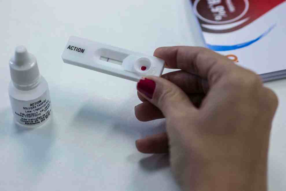 A woman shows how an HIV self-test kit works in Rio de Janeiro