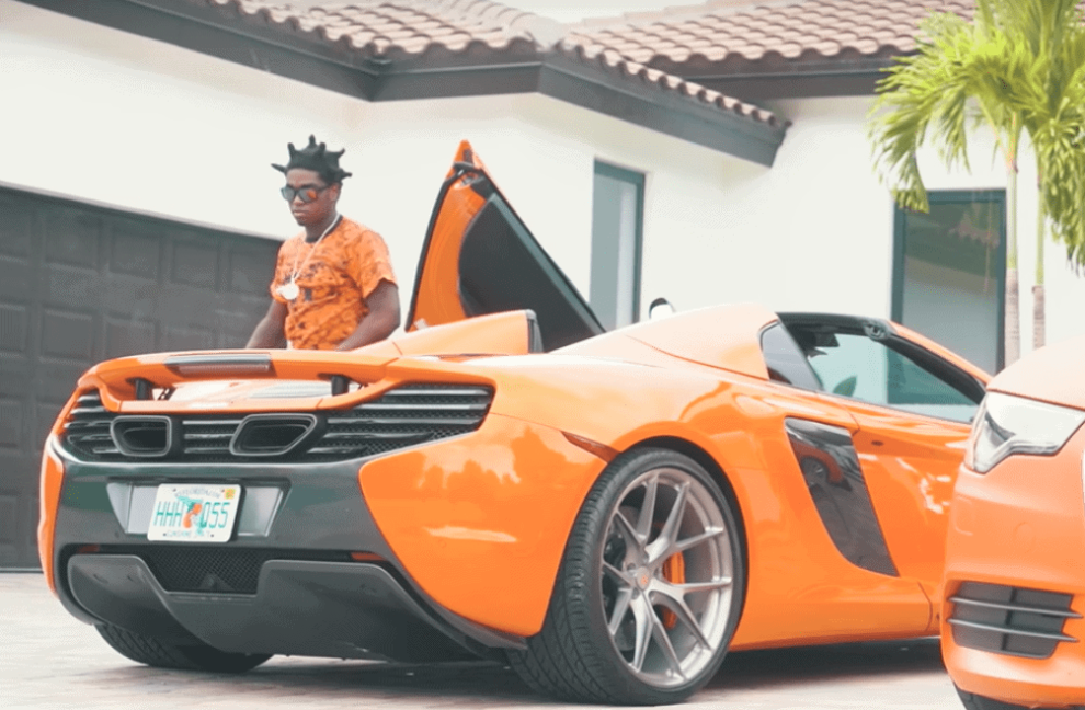 Kodak Black in front of orange sports car