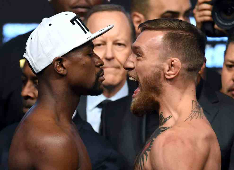 Floyd Mayweather Jr. and Conor McGregor face off during their official weigh-in at T-Mobile Arena on August 25