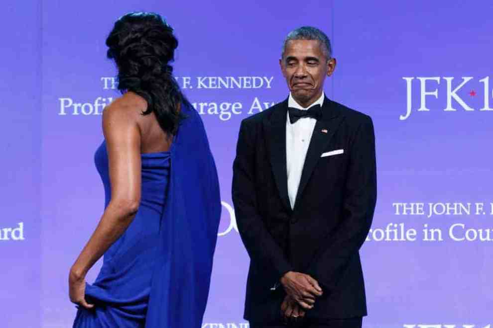 Barak Obama watches as his wife