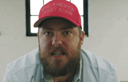Still from video of Joyner's 'I'm not racist" video showing a bearded white man in a MAGA hat