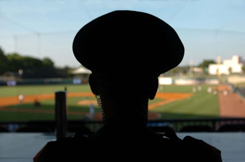 Silhouette of security officer overlooking baseball field