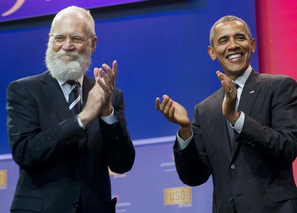 US President Barack Obama applauds alongside David Letterman during a celebration of the 75th anniversary of the USO
