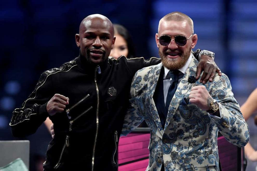 Floyd Mayweather Jr. and Conor McGregor pose for pictures during a news conference after Mayweather's 10th-round TKO victory
