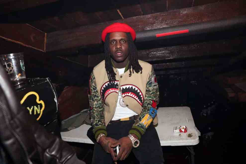 Chief Keef wearing a red hat and multi-color jacket
