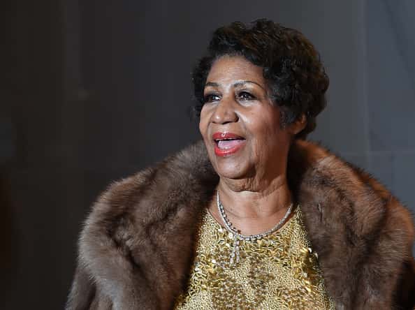 Aretha Franklin in gold dress and fur coat