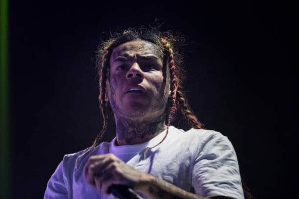 Tekashi 6ix9ine wearing white on stage
