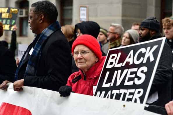 White woman holding black lives matter sign during protest