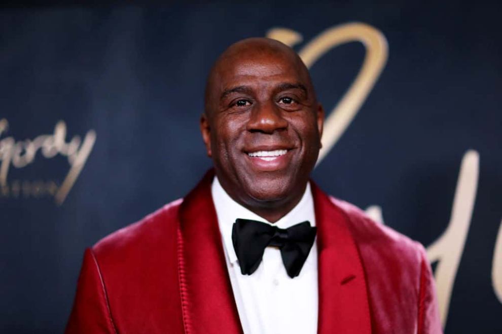 Magic Johnson wearing a red suit jacket