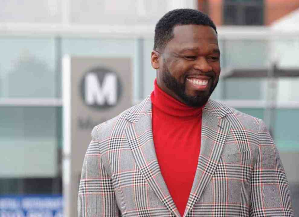 50 Cent wearing red sweater and plaid blazer
