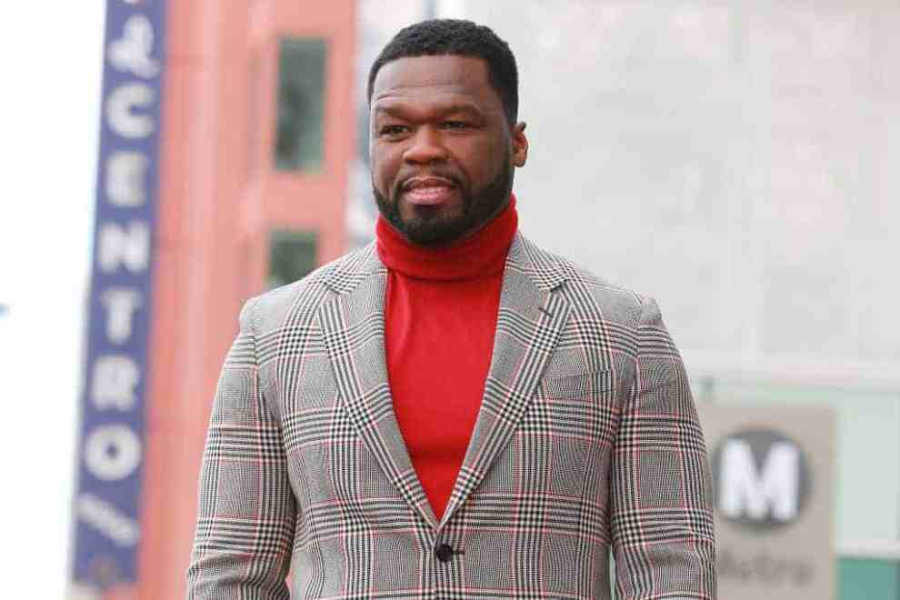 50 Cent wearing a red turtle neck and blazer
