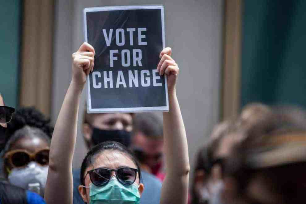Protestor holding up a Vote for change sign