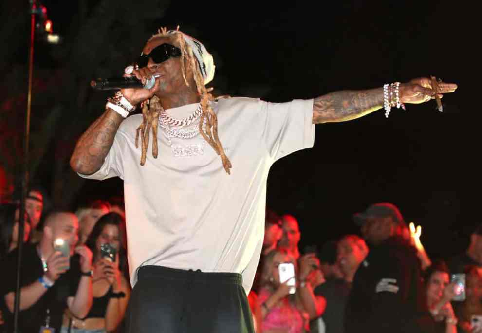 Lil Wayne performing in white at the World's Largest Pizza Festival