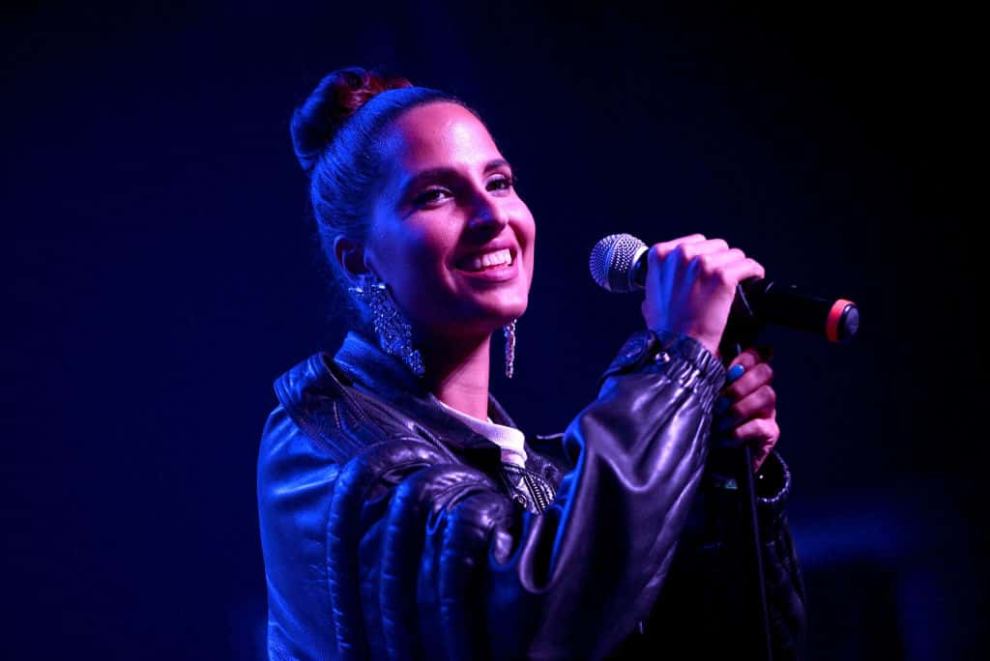 Snoh Aalegra holding the microphone and smiling