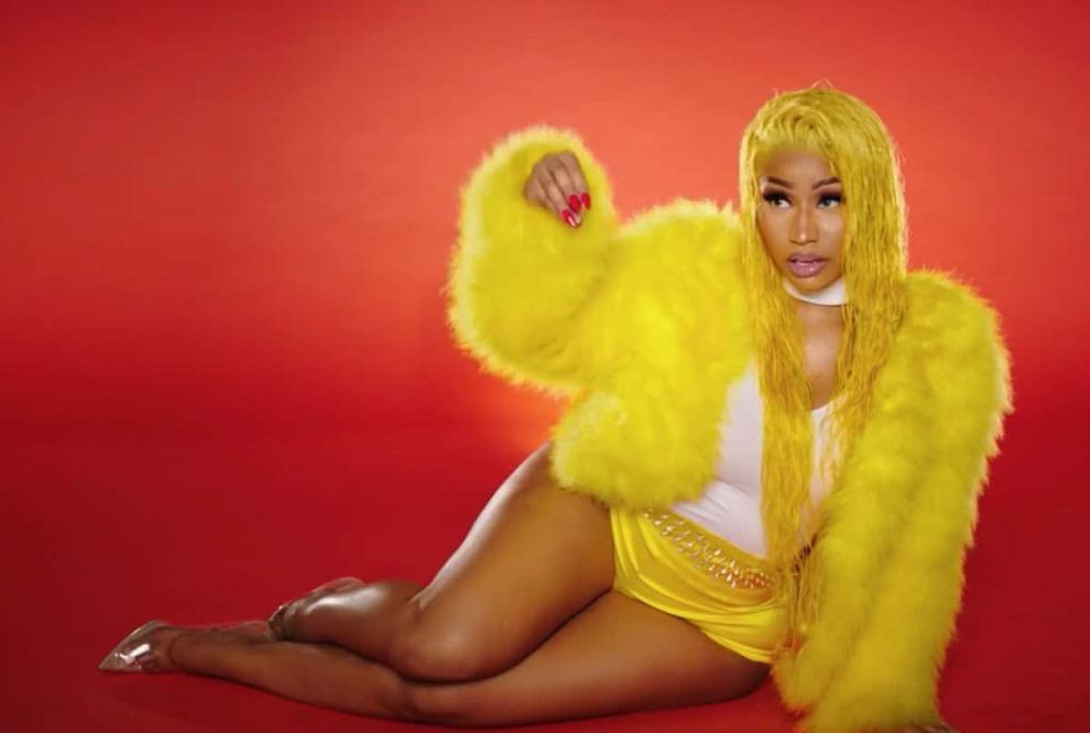 Nicki Minaj in yellow jacket agains red background from Barbie Dreams video