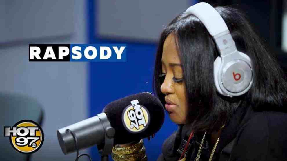 American Rapper Rapsody with headphones on at the Microphone sitting down