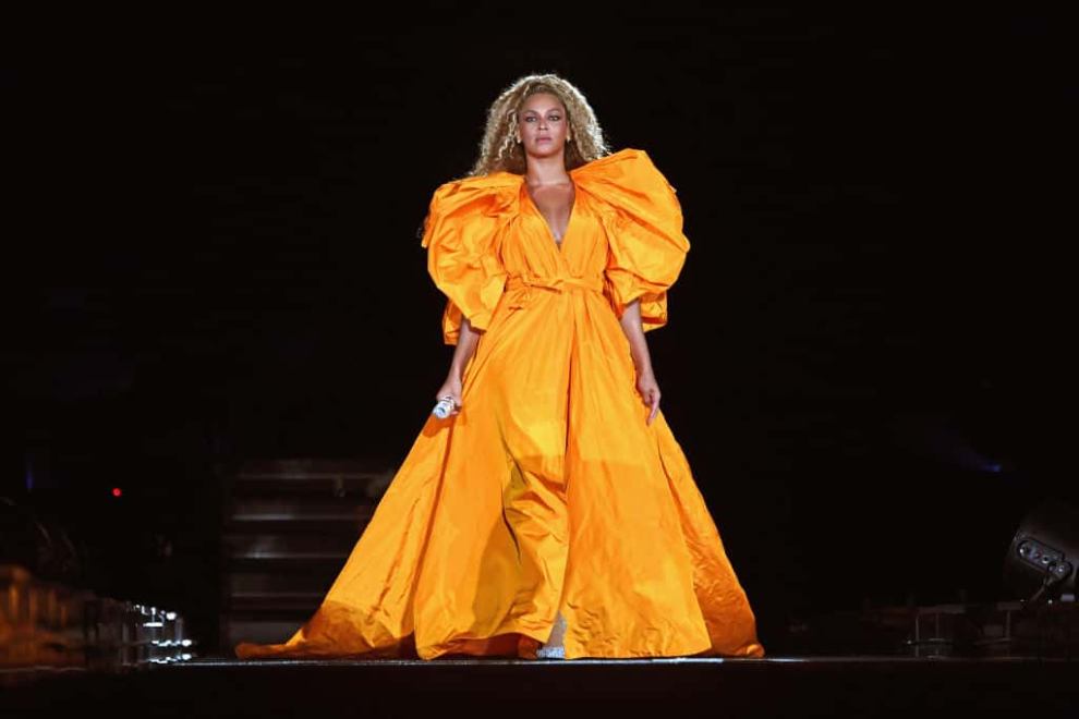 Beyonce wearing a yellow dress on stage